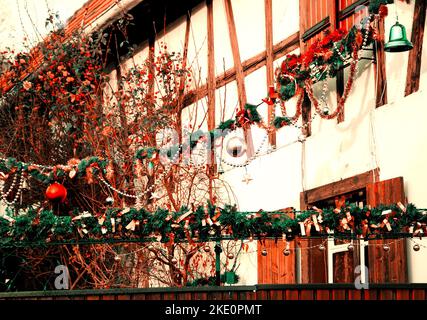 Tipica casa rurale a graticcio decorata per Natale. Alsazia, Francia. Foto dai toni. Foto Stock