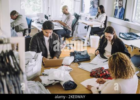 Vista ad angolo alto dei designer di moda che lavorano insieme in officina Foto Stock