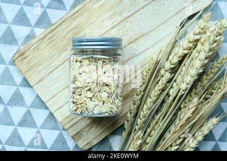 avena fiocchi in un vaso con cucchiaio sul tavolo Foto Stock