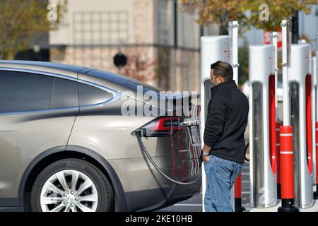 South Barrington, Illinois, Stati Uniti. Una Tesla viene ricaricata presso una stazione di ricarica per veicoli elettrici Tesla nel parcheggio di un centro commerciale di lusso. Foto Stock