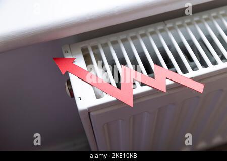 Costo di vivere crisi. Rosso freccia crescente su un radiatore. Aumento del costo dell'energia e delle bollette Foto Stock