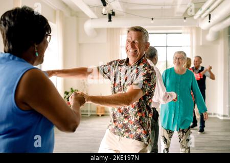 Felice coppia multirazziale anziana ballare insieme in classe Foto Stock
