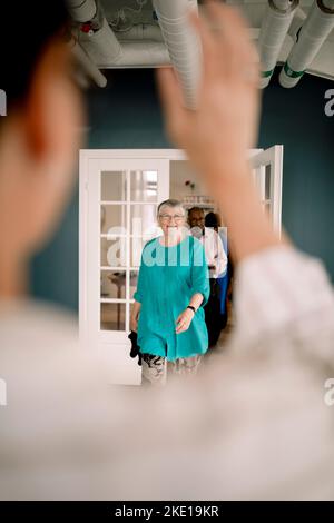 Donna e uomo anziano sorridenti in arrivo in classe di danza Foto Stock