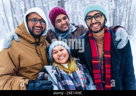 quattro persone scattano selfie all'aperto durante le vacanze di nuovo anno Foto Stock