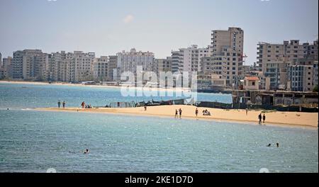 Spiaggia di Famagosta occupata e sorvegliata da soldati turchi di fronte al bombardamento di alberghi vuoti sulla spiaggia. Foto Stock