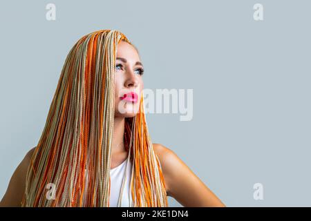 Trecce ragazza. Ritratto di bella ragazza giovane con trecce. Bella donna elegante con kanekalon colorato intrecciato nei suoi capelli. Bella donna colorata Foto Stock