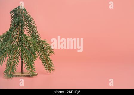 Albero di Natale fatto in casa sfondo rosa pastello. Banner design minimale Foto Stock