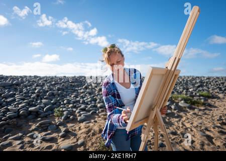 Artista Clare Willcks, nella foto, lavorando sulla spiaggia di Sandybere, North Devon. Foto Stock