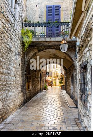 Vence, Francia - 6 agosto 2022: Strade strette con passaggio ad arco sotto case storiche colorate in Rue de l’Eveche nel quartiere storico Foto Stock