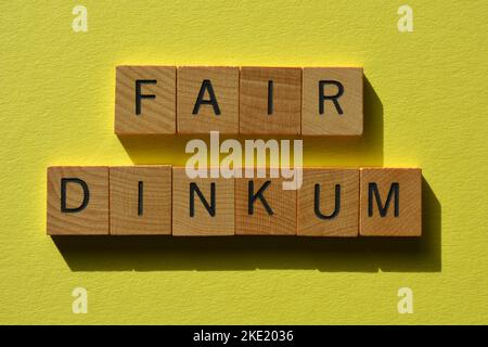 Buon dinkum, parola slang australiana per eccellente in lettere di alfabeto di legno isolato su sfondo giallo Foto Stock