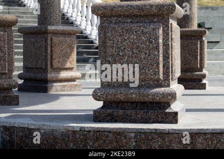 Grandi colonne di marmo marrone si chiudono sullo sfondo delle scale in stile vintage. Architettura urbana. Concetto di turismo. Foto Stock