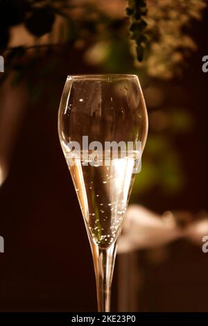 bicchiere con champagne in un'atmosfera dorata Foto Stock