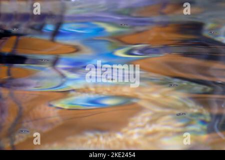 Riflessi sull'acqua come un dipinto colorato, in colori caldi e freddi Foto Stock