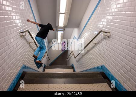 Lo skater che cavalca il suo skateboard alla scala del terreno Foto Stock