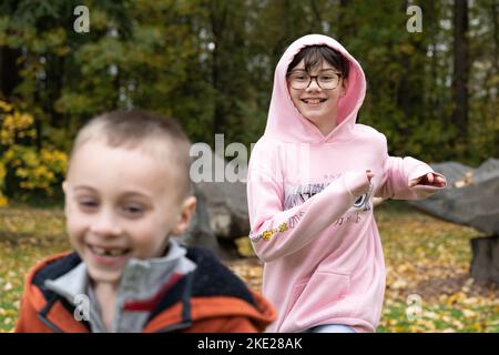 Due bambini felici che corrono in un parco, giocando. Foto Stock