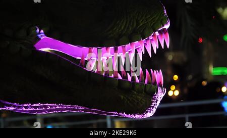 Parco dei dinosauri al Dubai Garden Glow Park, illuminato di notte. Molti dinosauri diversi, sembrano vivi. Foto di alta qualità Foto Stock