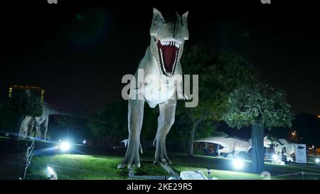 Parco dei dinosauri al Dubai Garden Glow Park, illuminato di notte. Molti dinosauri diversi, sembrano vivi. Foto di alta qualità Foto Stock