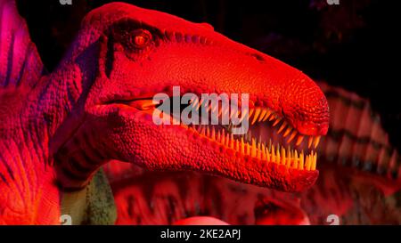 Parco dei dinosauri al Dubai Garden Glow Park, illuminato di notte. Molti dinosauri diversi, sembrano vivi. Foto di alta qualità Foto Stock