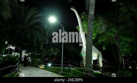 Parco dei dinosauri al Dubai Garden Glow Park, illuminato di notte. Molti dinosauri diversi, sembrano vivi. Foto di alta qualità Foto Stock