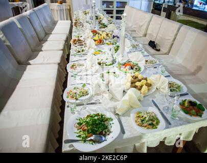 Piatto decorato con forchetta e cucchiaio. Tavolo allestito in stile boho con pampas erba e verde Foto Stock