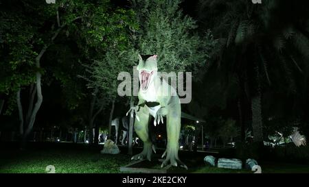 Parco dei dinosauri al Dubai Garden Glow Park, illuminato di notte. Molti dinosauri diversi, sembrano vivi. Foto di alta qualità Foto Stock