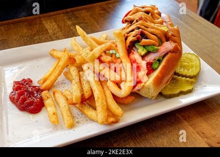 Sandwich con aragosta con avocado e mayo sud-occidentale su un piatto bianco con patatine fritte e ketchup Foto Stock