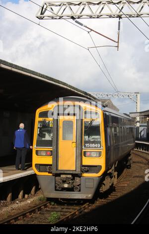 Guardia ferroviaria sulla piattaforma di treni del Nord espresso sprinter dmu in attesa di partire treno dalla stazione ferroviaria di Carnforth il 9th novembre 2022. Foto Stock