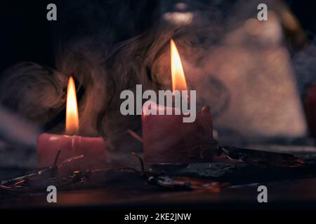 Composizione stregoneria con candele, libri, gioielli e pentagramma simbolo, concetto occulto, rituale magia nera Foto Stock