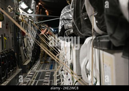 I militari dell'aeronautica degli Stati Uniti assegnati allo Squadrone di sollevamento di aeronautica di 8th ed ai soldati dell'esercito degli Stati Uniti assegnati alla società di Quartermaster di 824th, preparano il carico per un airdrop da un'aeronautica degli Stati Uniti C-17 Globemaster III assegnato alla 8th EAS alla base aerea di al Udeid, Qatar, 5 novembre 2022. Il carico faceva parte di una missione Combat airdrop in un luogo non divulgato nell'area di responsabilità del comando centrale degli Stati Uniti. (STATI UNITI Foto Air Force di Tech. SGT. Diana Cossaboom) Foto Stock