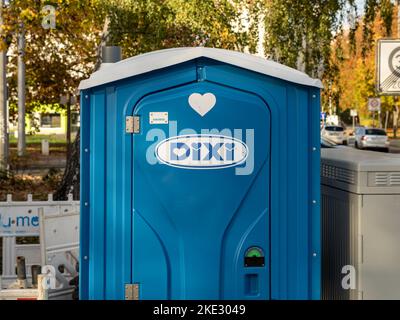 servizi igienici portatili Dixi in un cantiere. La cabina blu in materiale plastico è per gli operatori. Il cartello della società si trova sulla porta chiusa. Foto Stock