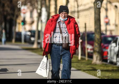 Un uomo anziano che cammina in Piazza del Re Tomislav (Trg Kralja Tomislava) durante l'inverno. Zagabria, Croazia Foto Stock