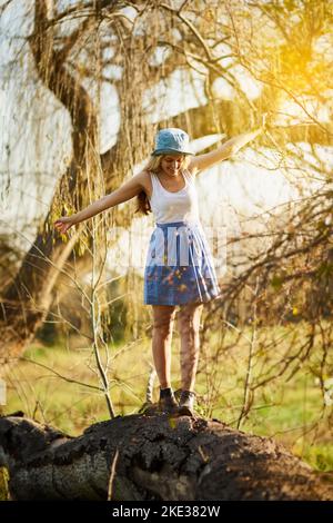 La bellezza della natura ci circonda: Una giovane donna su un albero si stoppa in campagna. Foto Stock