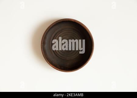 Le ceramiche profonde in terracotta sono in primo piano su uno sfondo bianco Foto Stock