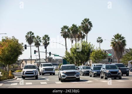 Vista incorniciata da palme delle auto che attraversano il centro di San Marcos, California, Stati Uniti. Foto Stock