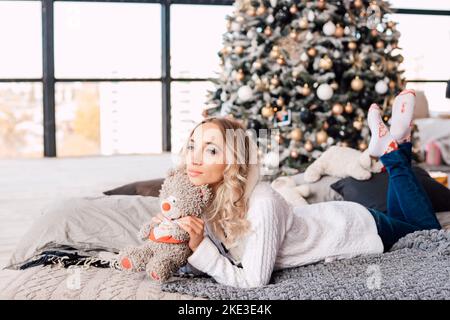 Una donna si trova sul letto e sogna per Natale nel soggiorno Foto Stock