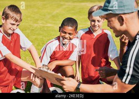 Calcio, bambini e allenatore con appunti di conversazione piano di gioco, squadra di formazione e sul campo di calcio all'aperto per fitness, competizione e sport Foto Stock