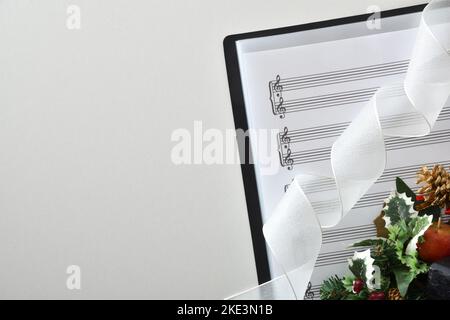 Musica corale di natale di sottofondo con musica spartiti e decorazione natalizia su tavolo bianco. Vista dall'alto. Foto Stock