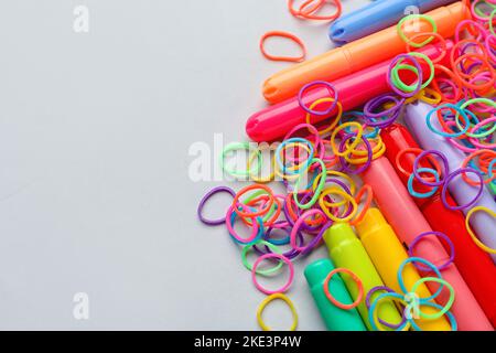 Fasce e pennarelli colorati in gomma su sfondo bianco Foto Stock