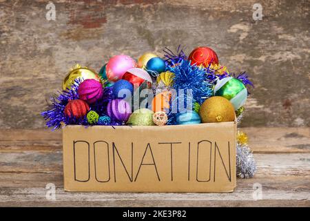 Scatola donazione con decorazioni natalizie. Regalo. Albero di Natale giocattolo. Foto Stock