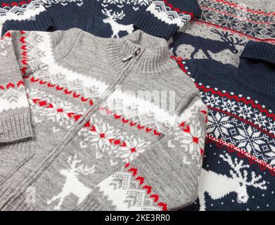 Diversi cardigan di lana scandinavi a maglia per bambini con motivo di rosa norvegese (Selburose) e ornamento di alce o cervi noto come Ugly Christma Foto Stock