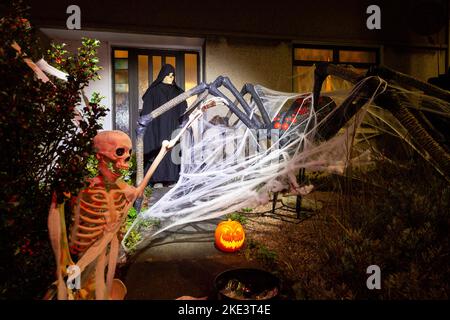 Una casa scozzese che celebra Halloween con un gigantesco ragno e scheletro decorazione. Foto Stock