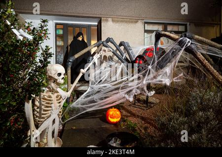 Una casa scozzese che celebra Halloween con un gigantesco ragno e scheletro decorazione. Foto Stock