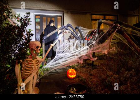 Una casa scozzese che celebra Halloween con un gigantesco ragno e scheletro decorazione. Foto Stock