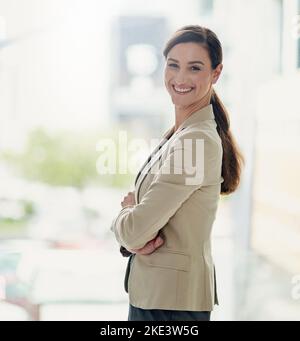 L'auto-assicurazione guida il successo di carriera. Ritratto di una donna d'affari felice e fiduciosa che lavora in un ufficio moderno. Foto Stock