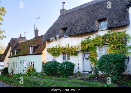 Case in paglia lungo la strada principale in autunno. Long Crendon, Buckinghamshire, Inghilterra Foto Stock