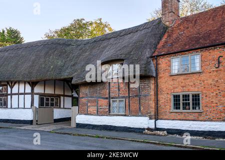 Case in paglia lungo la strada principale in autunno. Long Crendon, Buckinghamshire, Inghilterra Foto Stock