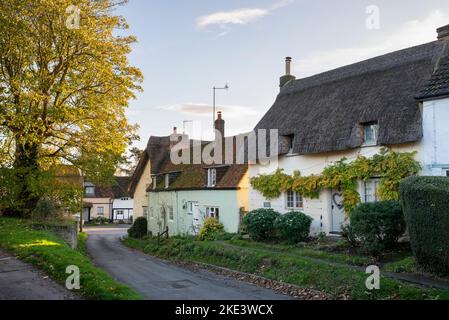 Case in paglia lungo la strada principale in autunno. Long Crendon, Buckinghamshire, Inghilterra Foto Stock