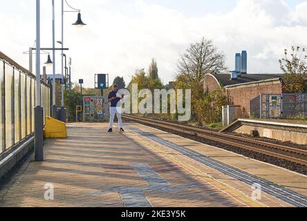 Uomo solitario in piedi su una piattaforma ferroviaria a Mansfield, Nottinghamshire, Regno Unito Foto Stock