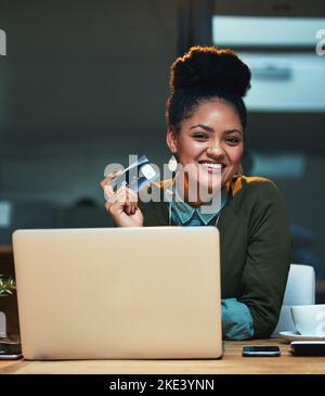Male basta metterlo sul conto aziendale. Ritratto di una giovane donna attraente shopping online mentre lavora in ufficio. Foto Stock