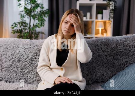 Donna malata che tocca la fronte Foto Stock